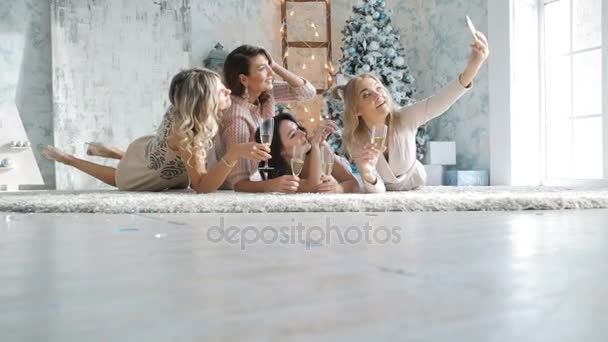 Giovani donne che si divertono e fotografano selfie su smartphone alla festa di Natale. Sexy felice gruppo di amici a festa glamour divertirsi sorridendo festeggiare il nuovo anno vigilia — Video Stock