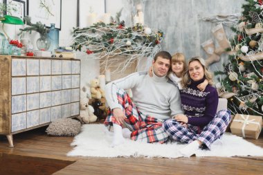 Noel hediyeleri ile eğlenceli, mutlu bir aile. Anne ve küçük bebek eğleniyor Noel ağacı yakınındaki odaya. Sevgi dolu aile ile Noel ağacı