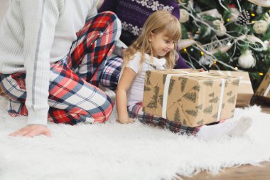 Mutlu aile Noel evde katta oturan hediye açılış