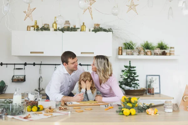 Familia feliz, madre joven con bebé, niña haciendo galletas de jengibre en la cocina decorada con árbol de Navidad. Hornear y cocinar con los niños para Navidad en casa . — Foto de Stock