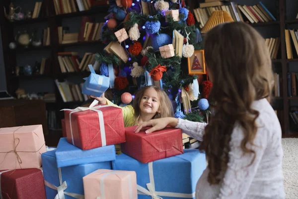 Pequeña hermosa chica bonita dando un regalo a su madre embarazada feliz - en el interior — Foto de Stock