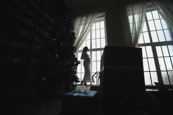 Madre embarazada cerca del árbol de Navidad — Foto de Stock