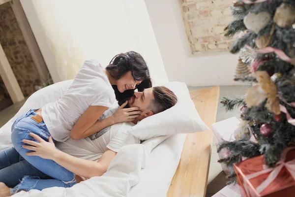 Glückliches Liebespaar auf dem Bett. Weihnachtsinterieur. Liebespaar zusammen — Stockfoto