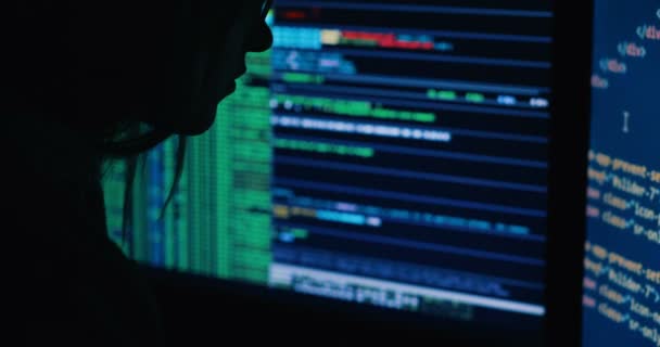 Актор в коді розтріскування капота використовує ноутбук і комп'ютери зі своєї темної хакерської кімнати — стокове відео