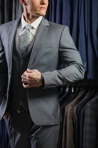 Ο πελάτης είναι κομψό τύπος στο σακάκι. Σε το φόντο κλασικό κοστούμια και τα σακάκια — Φωτογραφία Αρχείου