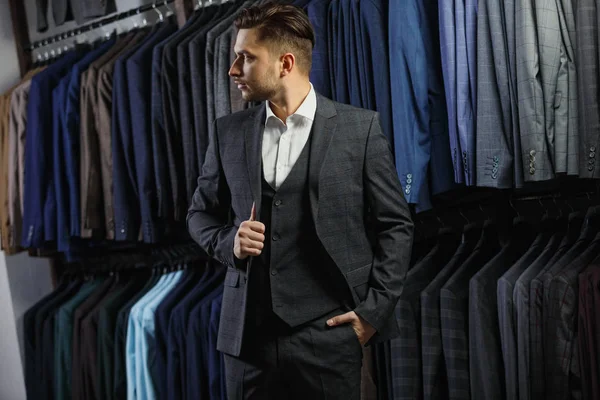 Όμορφος Καυκάσιος επιχειρηματίας ντυμένος με το κοστούμι. Σε το φόντο κλασικό κοστούμια και τα σακάκια — Φωτογραφία Αρχείου