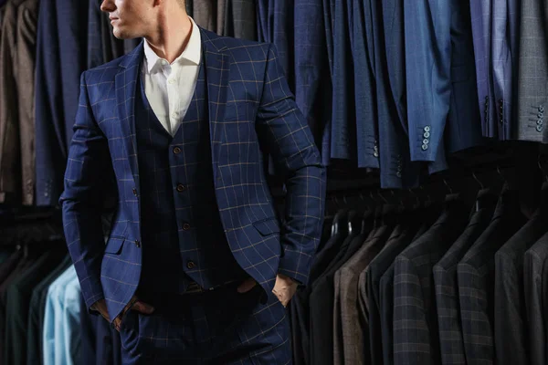 Il cliente e 'un ragazzo elegante con la giacca. Sullo sfondo abiti e giacche classiche — Foto Stock
