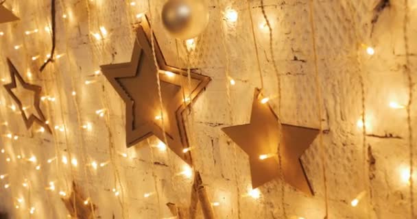 Guirnalda de Navidad con luces doradas, primer plano. Luces centelleantes de las estrellas de Navidad. Concepto de vacaciones de invierno . — Vídeos de Stock