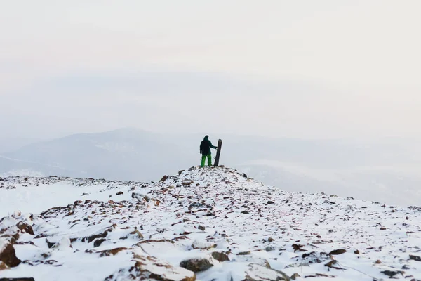 Homem snowboarder fica com snowboard no topo das montanhas. Estância de esqui Sheregesh — Fotografia de Stock