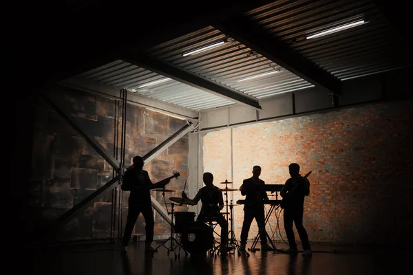 Müzik grubu ve moda. Rock ve şarkı şarkı çalmaya elbiseli yakışıklı genç adamlar. Bantları siluetleri ile bir konser.