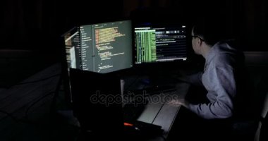 Haritalar ve veriler üzerinde göstermek perde bir karanlık office odada bulunan bir bilgisayarda bir Hood erkek hacker çalışır