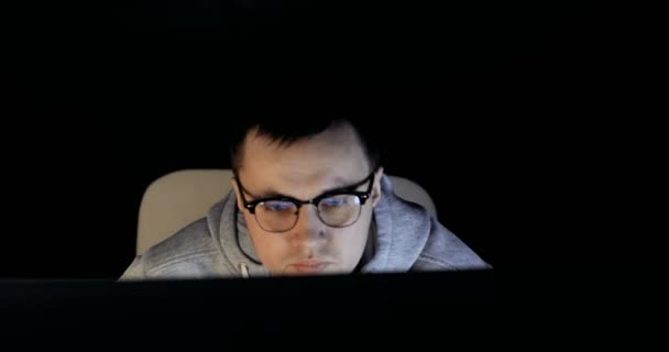 Male hacker working on a computer. hacker in glasses is working on computer in cyber security center filled with display screens. — Stock Video