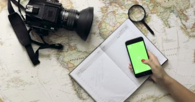 Üstten Görünüm kadın Gezgin el cep telefonu app vintage harita yukarıdan kullanarak tatil Planlama