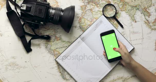 Vista dall'alto donna viaggiatore mani pianificazione vacanza utilizzando cellulare app mappa vintage dall'alto — Video Stock