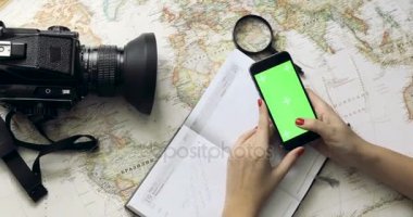 Üstten Görünüm kadın Gezgin el cep telefonu app vintage harita yukarıdan kullanarak tatil Planlama