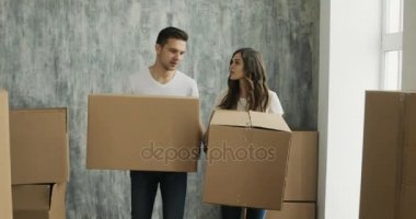 Kutuları içine yeni ev Taşınma günü üzerinde taşıyan çift. Genç aile yeni ev taşıma