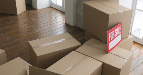 Новые владельцы распаковывают коробки. трогательный день. большие картонные коробки в новом доме — стоковое видео