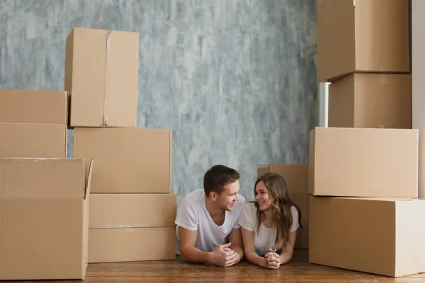 Felice ma stanca giovane coppia sdraiata sul pavimento della loro nuova casa — Foto Stock