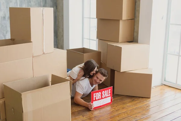 Felice ma stanca giovane coppia sdraiata sul pavimento della loro nuova casa — Foto Stock