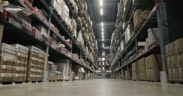 Camera moves between palettes with cardboard boxes and different materials in a storage warehouse. Dolly shoot — Stock Video