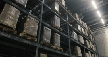 Kamera paletleri ile karton kutular ve bir depo farklı materyaller arasında hareket eder. Dolly ateş