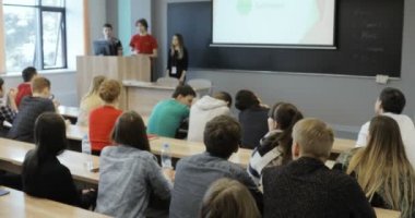 Arkadan görünümünü bir grup öğrenci bir sınıfta bir ders öğretmenleri tutar olarak dinleme. Arkadan Görünüm