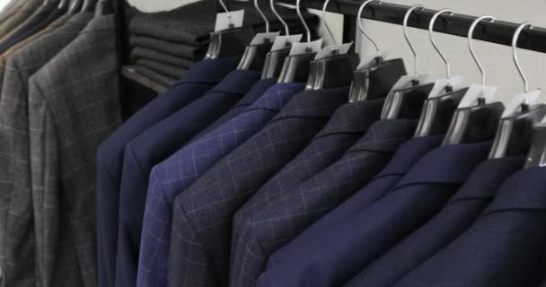 Mens suit at tailors shop. Mens hands choose a jacket in their wardrobe. Male choosing — Stock Video