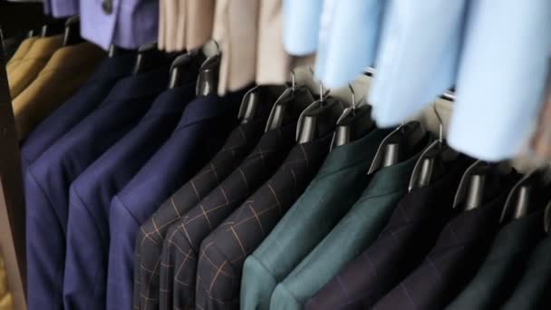 Traje de hombre en sastrería. Las manos de hombre eligen una chaqueta en su armario. Elegir masculino — Vídeos de Stock