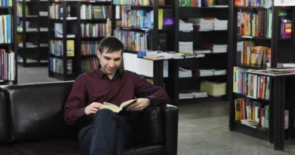 Estudante a ler um livro na biblioteca. Conceito: educativo, retrato, biblioteca, e estudioso, relaxar . — Vídeo de Stock