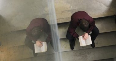 Kütüphanede üniversitede okuyan öğrenci konsantre