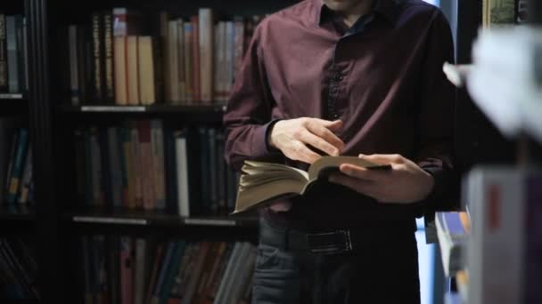 Φοιτητής διαβάζοντας ένα βιβλίο στη βιβλιοθήκη. έννοια της εκπαίδευσης — Αρχείο Βίντεο