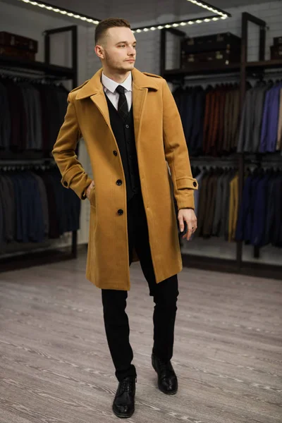 Όμορφος νεαρός σε παλτό στο κατάστημα κοστούμι — Φωτογραφία Αρχείου