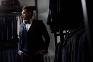 İstemci bir ayna salonu takım elbiseli üzerinde çalışırken zarif biri. Arka plan Klasik takım elbise ve ceket