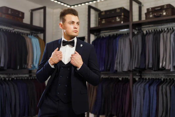 Młody człowiek w klasyczny vest rzędu garnitury w sklepie — Zdjęcie stockowe