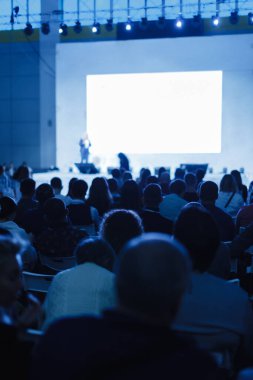 İş ve Girişimcilik konsepti. Sözcü, iş konferansında konferans salonunda konuşma yapacak. Konferans salonundaki izleyiciler. Tanınmayan insanlara odaklan.