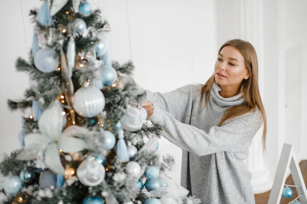 一个穿毛衣的女孩装饰着圣诞树。 新年概念. — 图库照片
