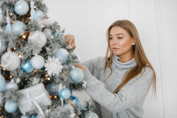 Närbild bild av kvinna i tröja dekorera julgran med grannlåt — Stockfoto
