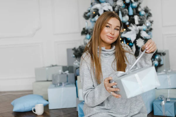 Feliz joven con regalos cerca del árbol de Navidad — Foto de Stock