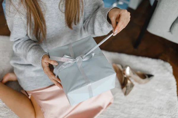 Noel ağacının yanında hediyeleri olan mutlu genç bir kadın. en üstteki görünüm