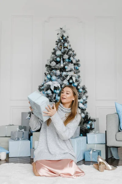 Feliz joven mujer vomita regalos cerca del árbol de Navidad — Foto de Stock