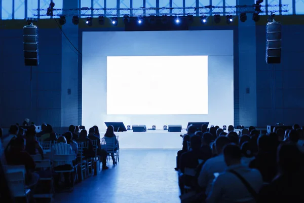 Público en la sala de conferencias. Concéntrate en la escena. La gente está esperando al orador. foto teñida de azul — Foto de Stock