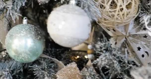 Close-up bekijken kerstboom versierd met zilveren speelgoed, geschenken, ballen, slingers. — Stockvideo
