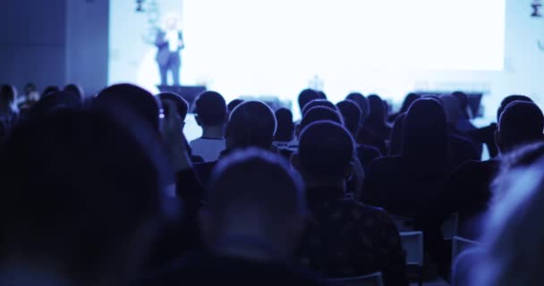 Mujer hablando en el escenario en el foro de negocios para startuppers, vista desde el auditorio . — Vídeo de stock