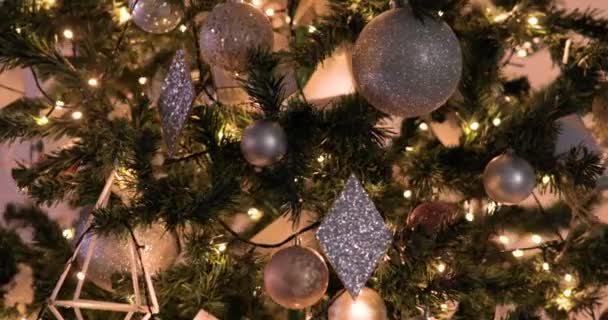 Girando em torno da árvore de Natal decorada com bolas douradas e guirlandas . — Vídeo de Stock