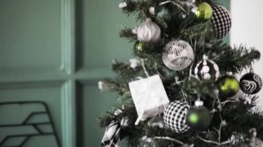Siyah, beyaz ve gümüş oyuncaklarla süslenmiş Noel ağacı, hediyeler, toplar.