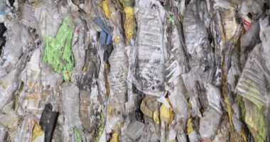 Geri dönüşüm fabrikasındaki depoda tekrar kullanılacak plastik paketleri sıraladım..