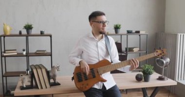 Genç adam, mola sırasında kulaklıkları kulağında gitar çalıyor..