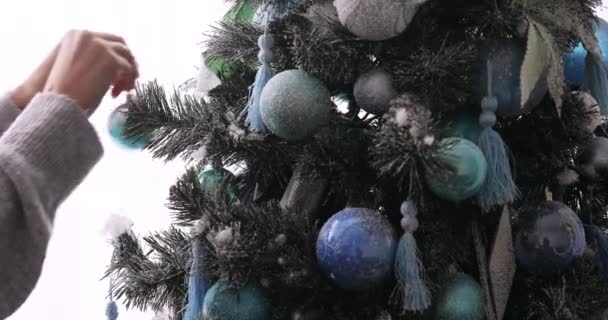 Mujer cuelga la pelota en el árbol de Navidad lo decora a las vacaciones, las manos de cerca . — Vídeos de Stock