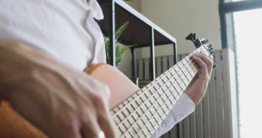 İşadamı gitar çalıyor ve bundan zevk alıyor. Ofiste oturuyor, yandan bakıyor..