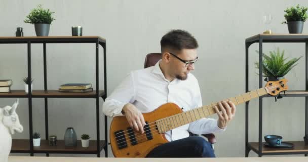 Businessman sta giocando con la chitarra e si diverte seduto in ufficio durante la pausa . — Video Stock